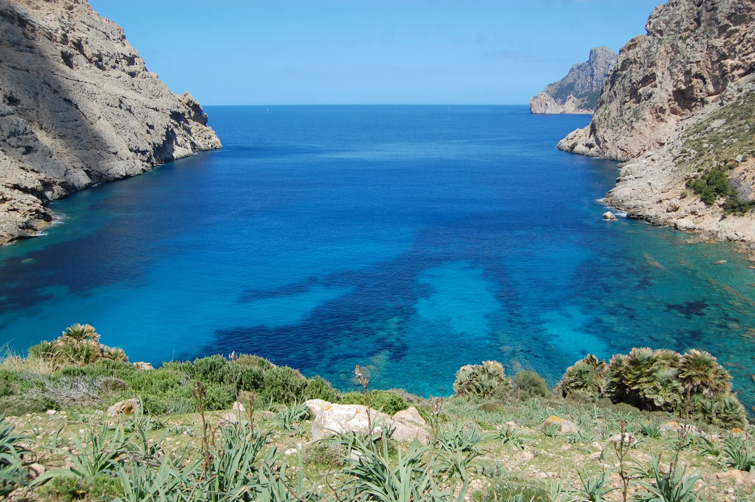 Cala Bóquer vista desde lo alto, con el agua azul intenso entre dos paredes de roca y el mar abierto al fondo