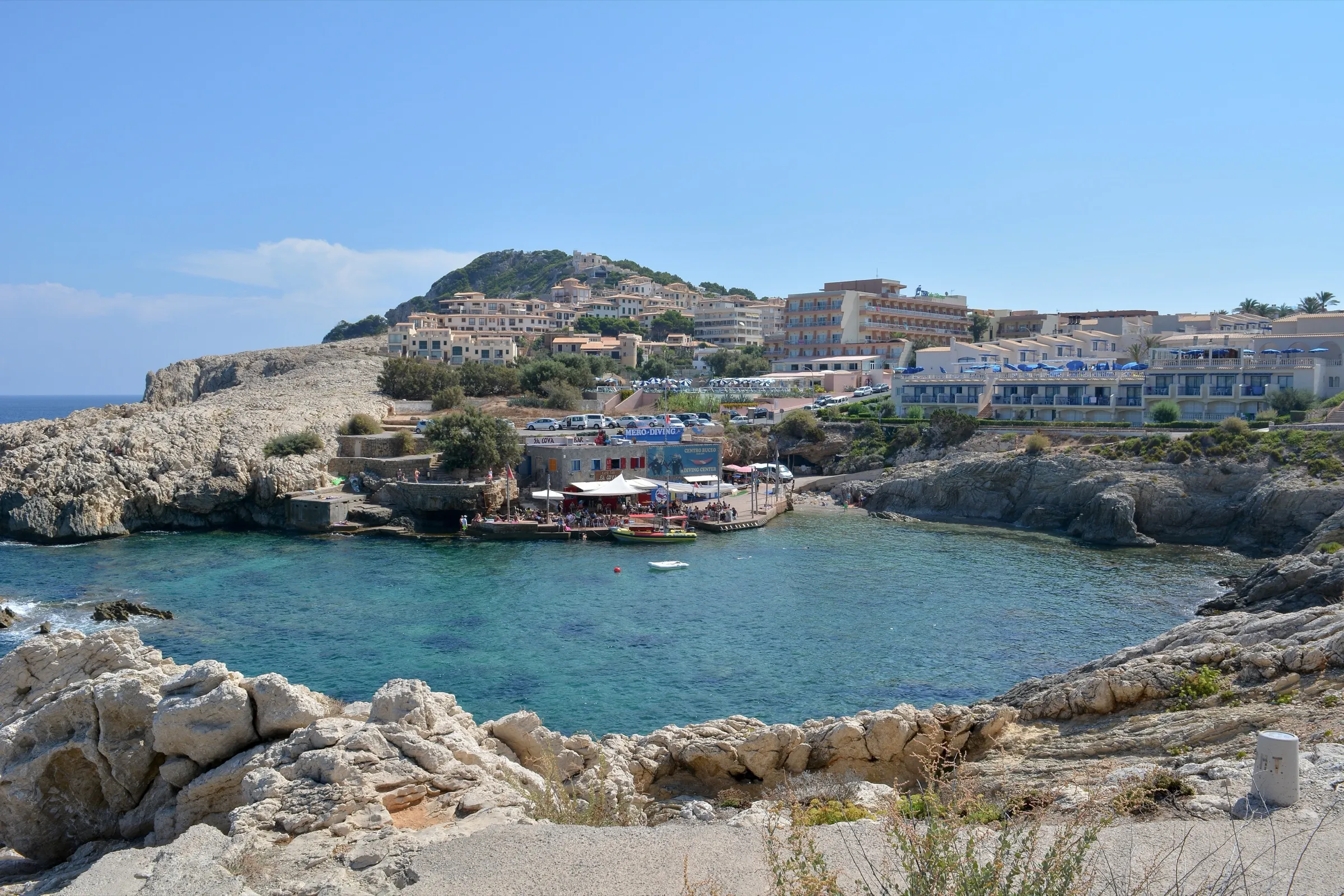 Die Bucht von den Felsen auf der anderen Seite aus, dahinter die Gebäude von Cala Rajada