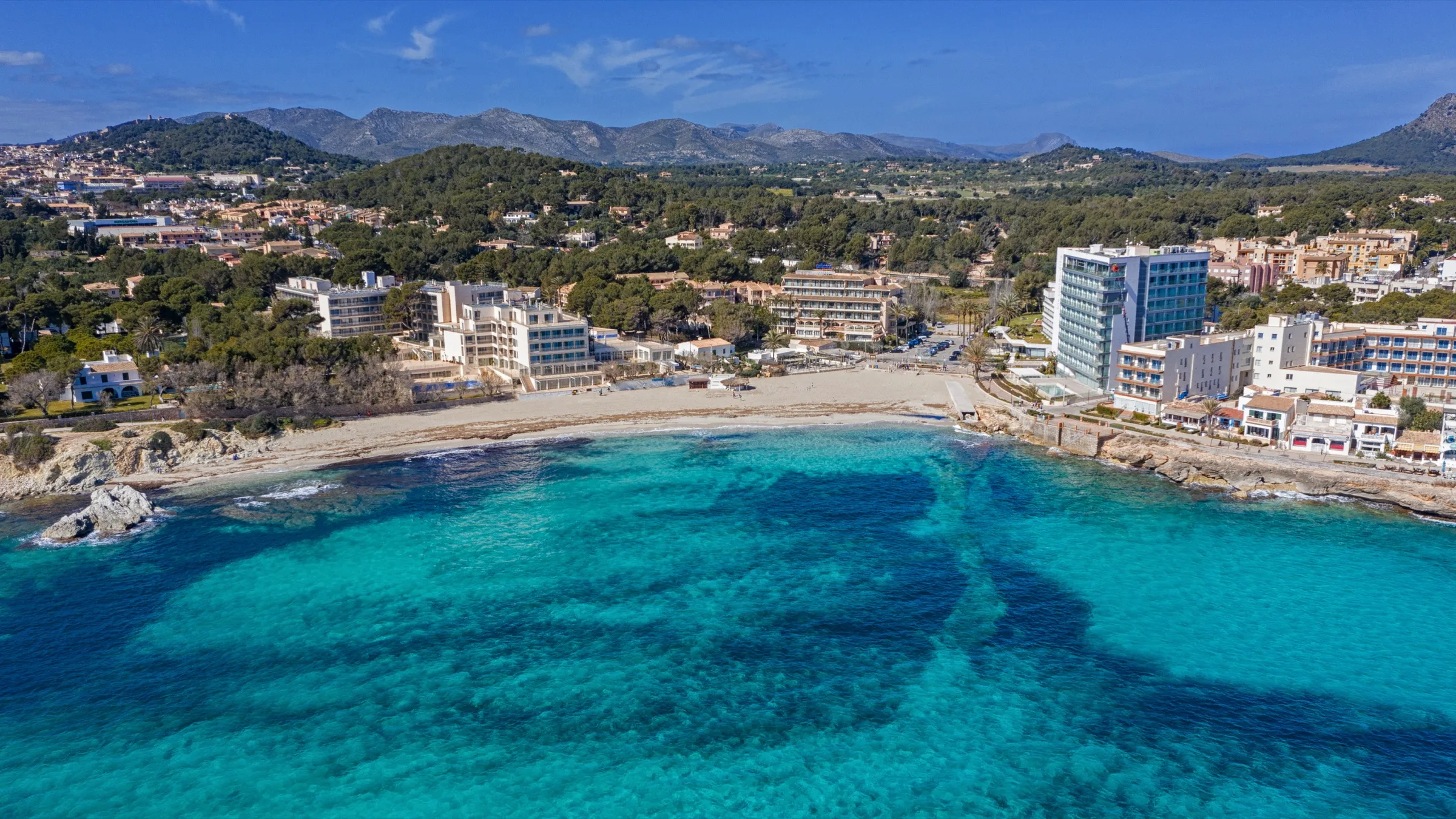 La bahía de Son Moll desde el aire, con el agua turquesa y los fondos oscuros de posidonia delante de la playa