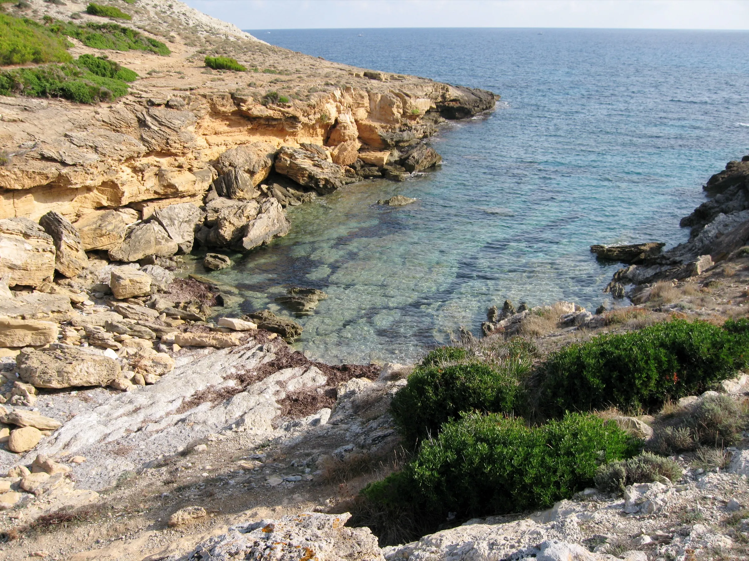 Cala Estreta vista desde dentro, con paredes de roca a los lados y el mar al fondo