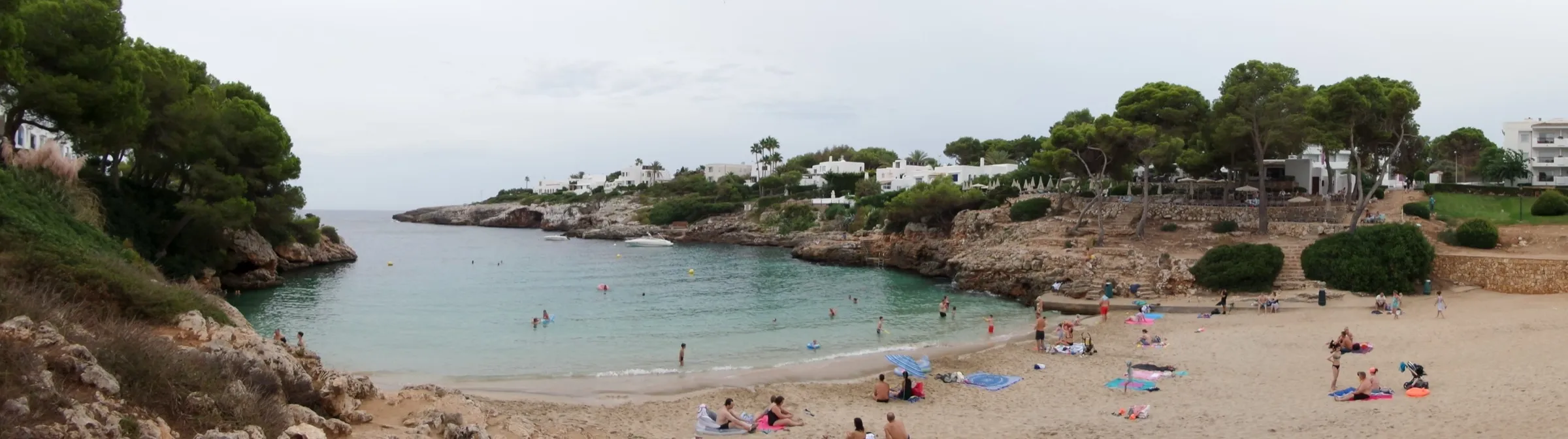 Vista panorámica de Cala Esmeralda con la playa al fondo del entrante, el pinar y las casas de Cala d'Or