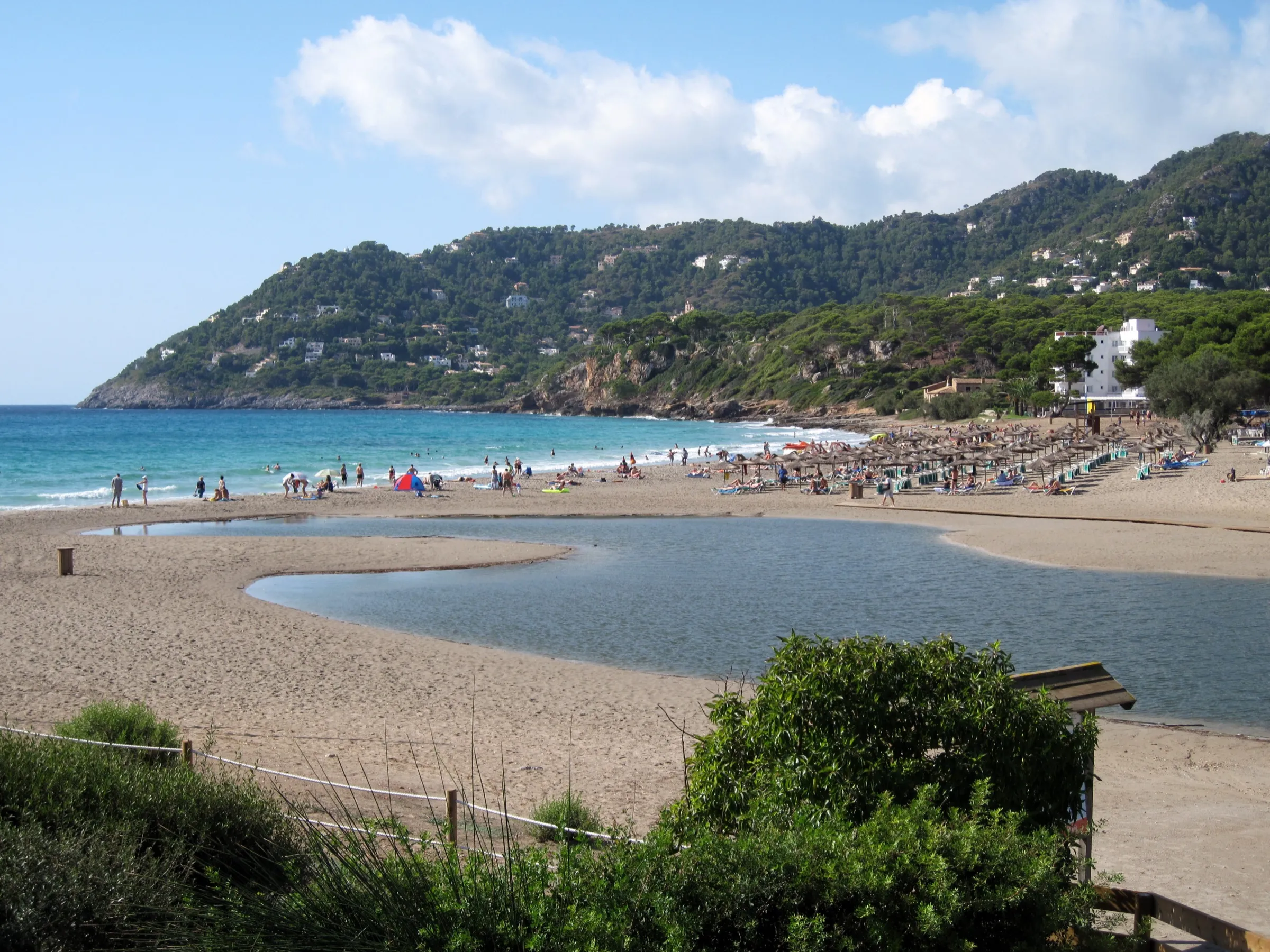 Die Lagune des Torrent de Canyamel auf dem Sand, mit dem Strand und der Küste im Hintergrund