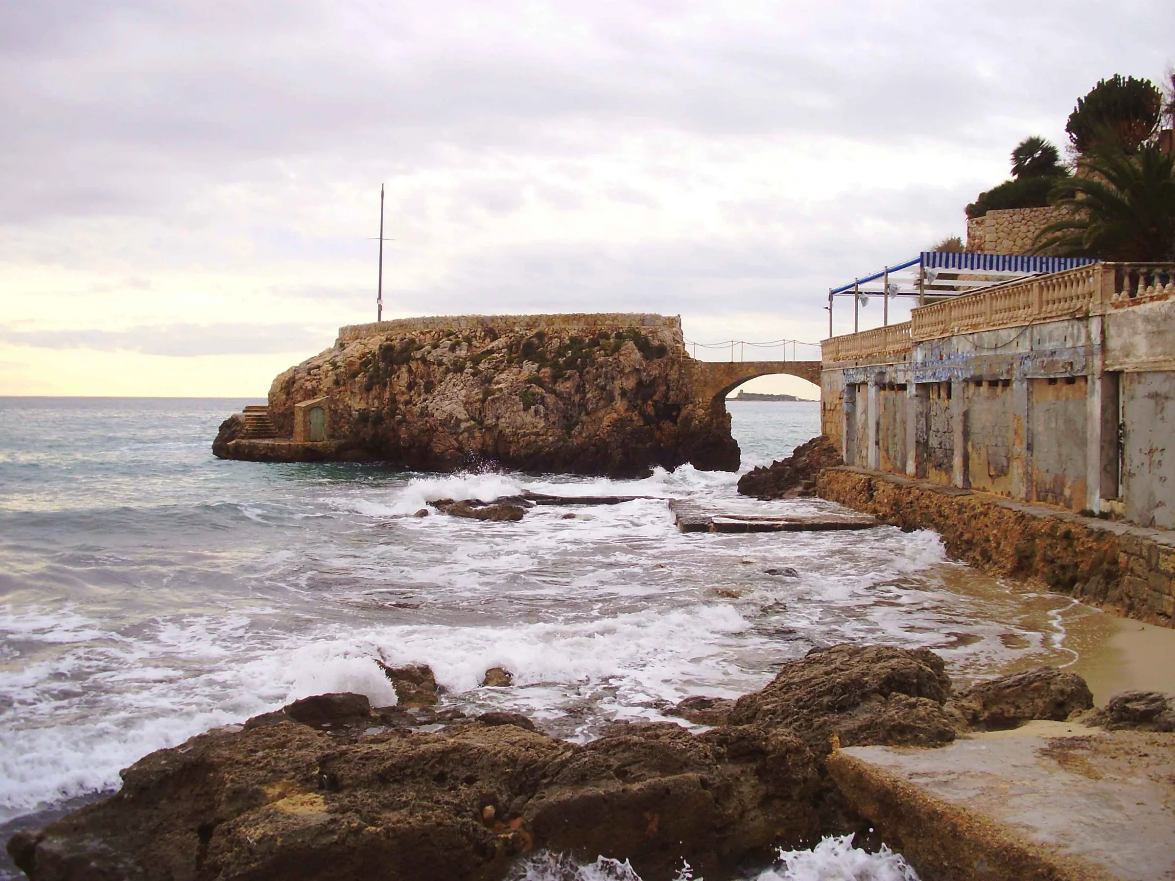 Rocks and an islet joined by a small bridge at the western end of Cala Major beach