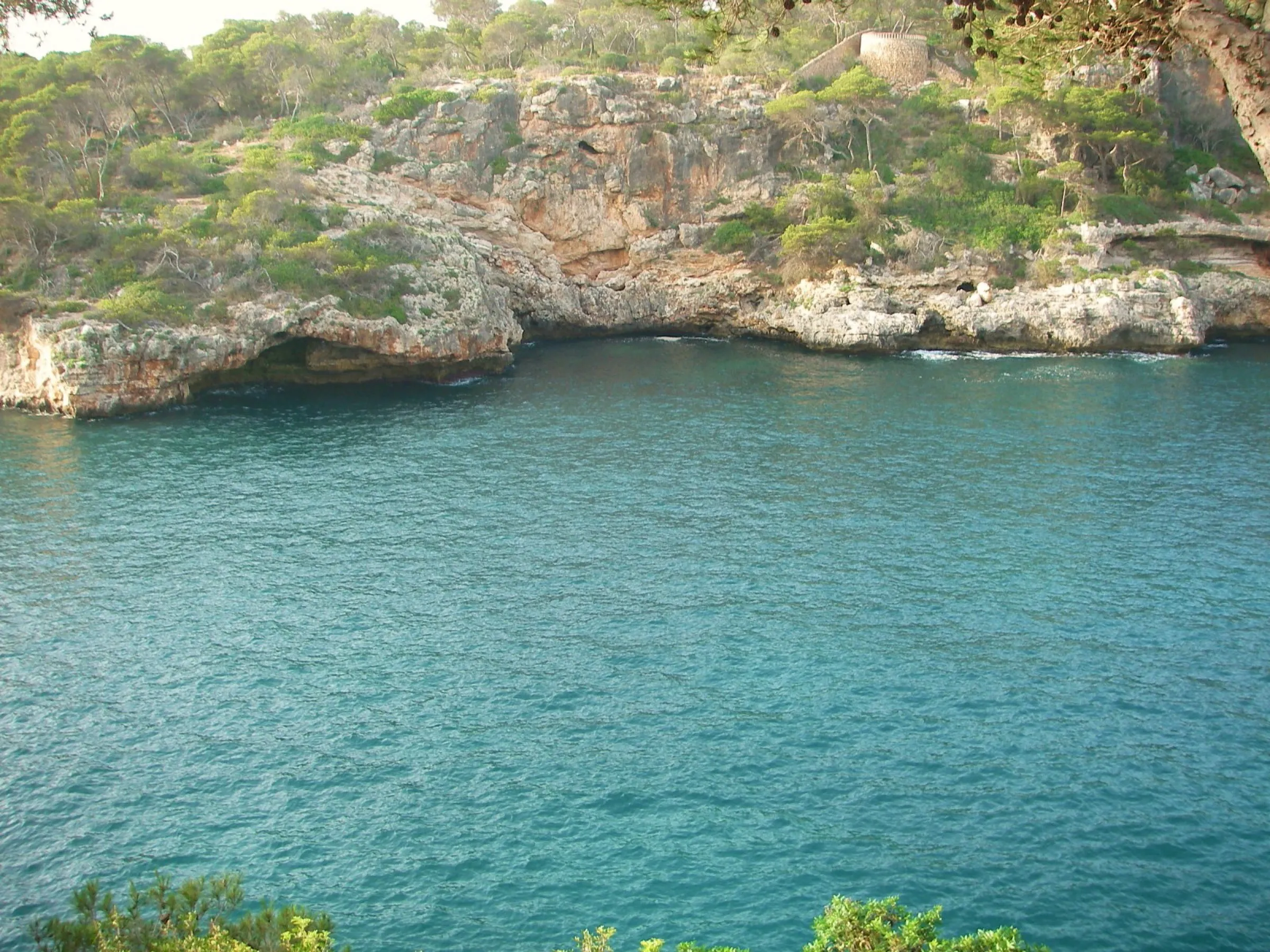 Turquoise water beside the rock cliffs of Cala Figuera