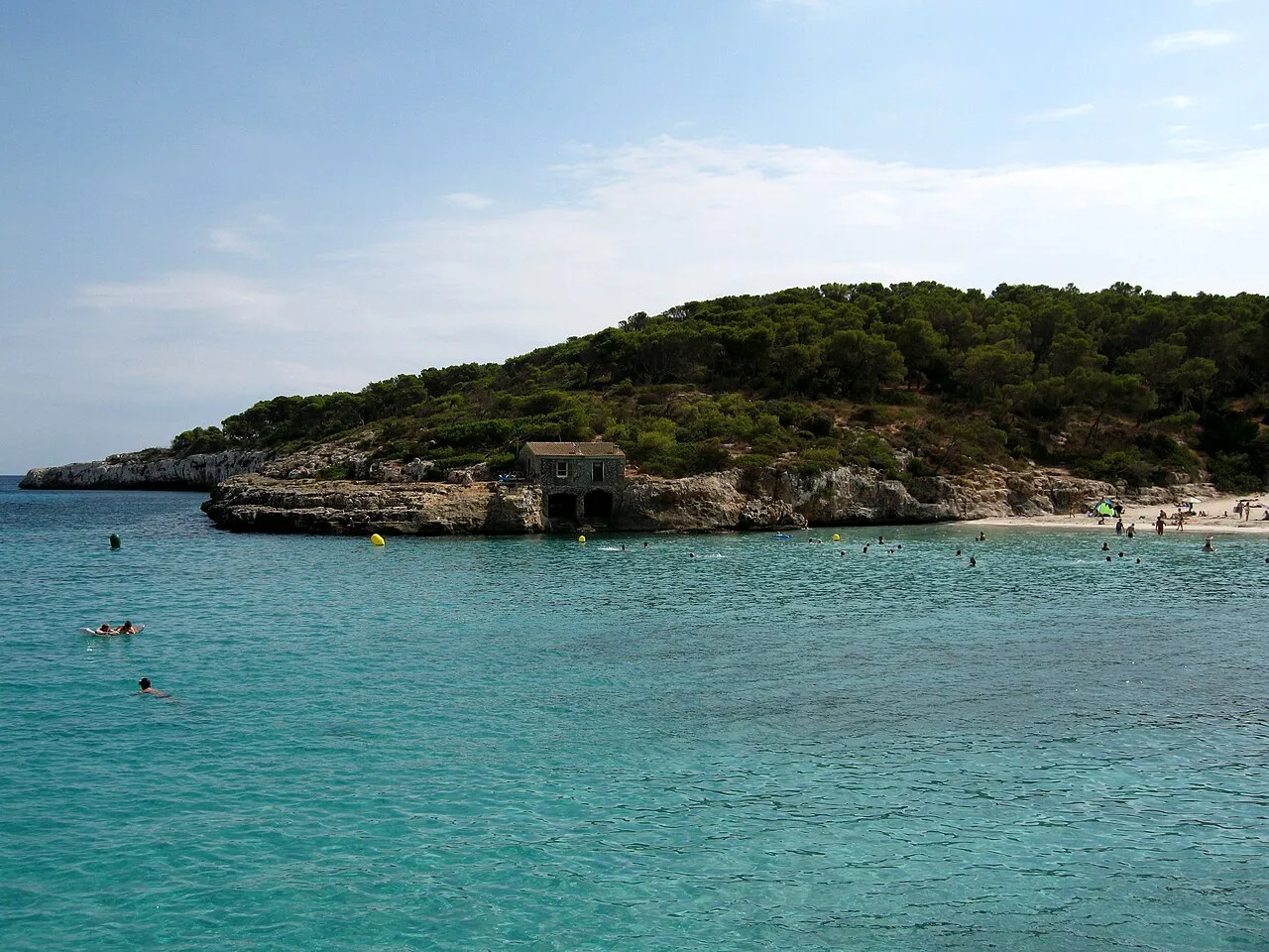 Punta rocosa con una caseta de piedra junto a la playa de s'Amarador