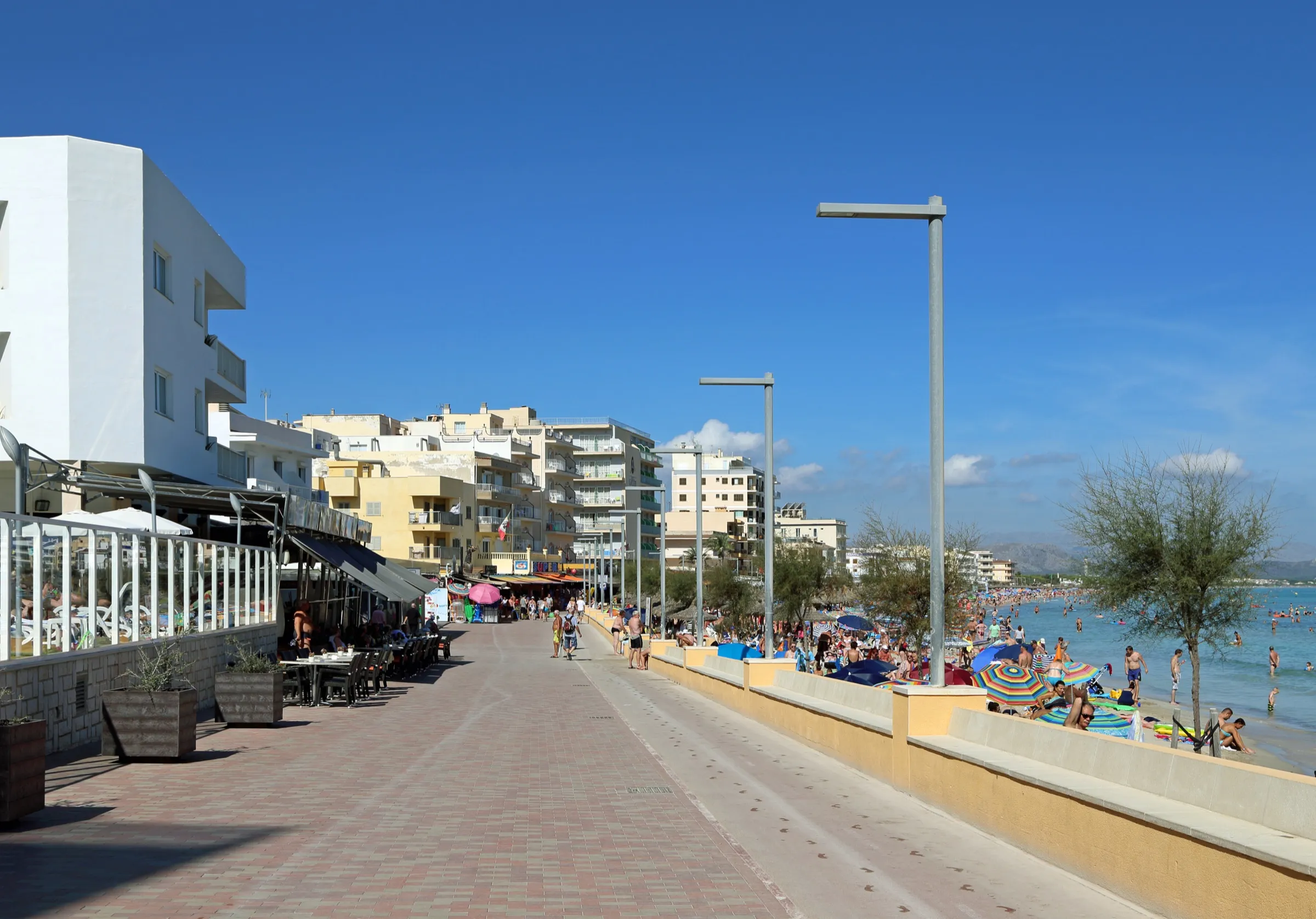 Can Picafort's seafront promenade, with terraces on one side and the beach on the other