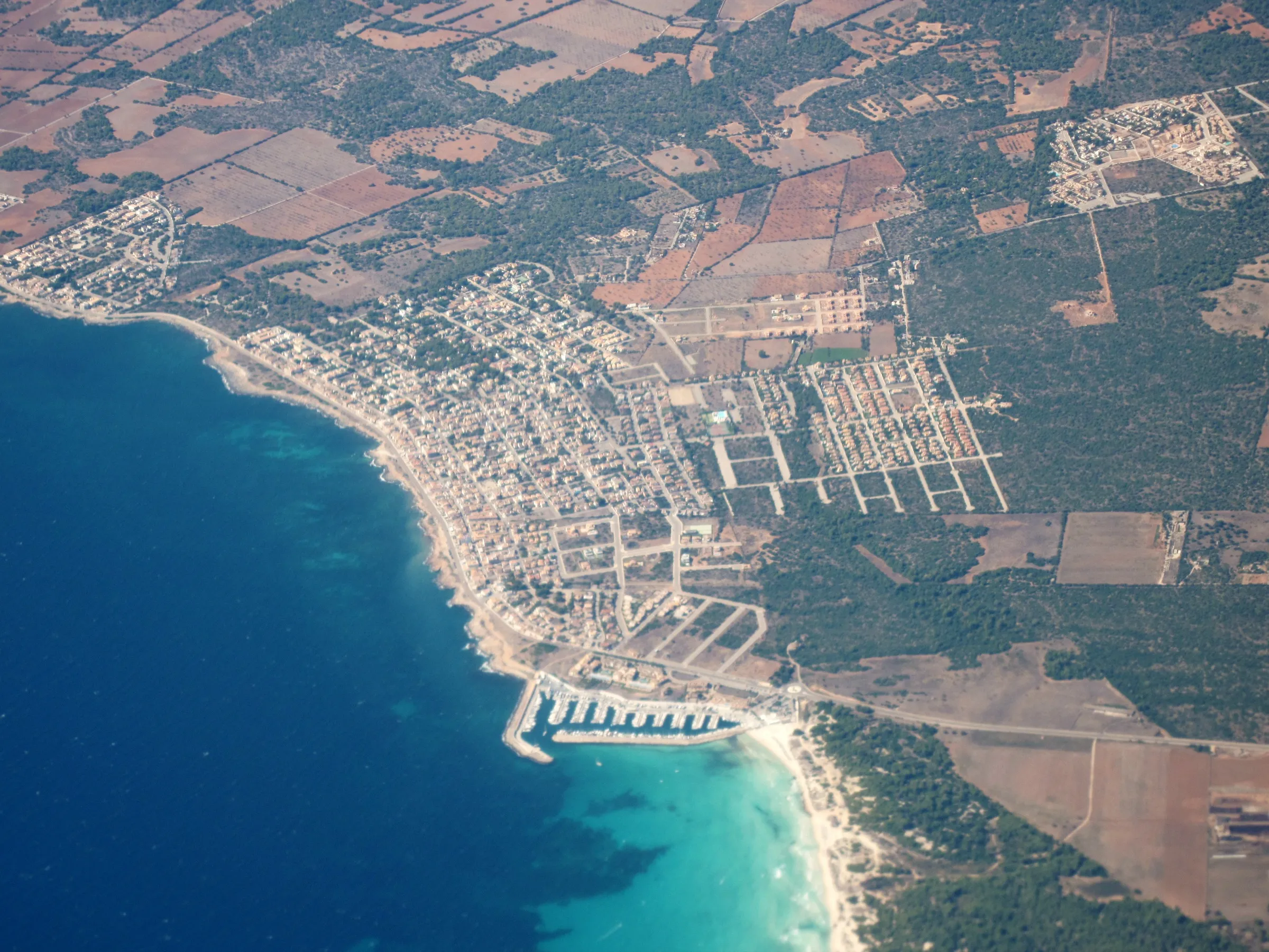 Vista aérea de sa Ràpita, con el puerto deportivo y el arenal de arena blanca que sigue hacia es Trenc