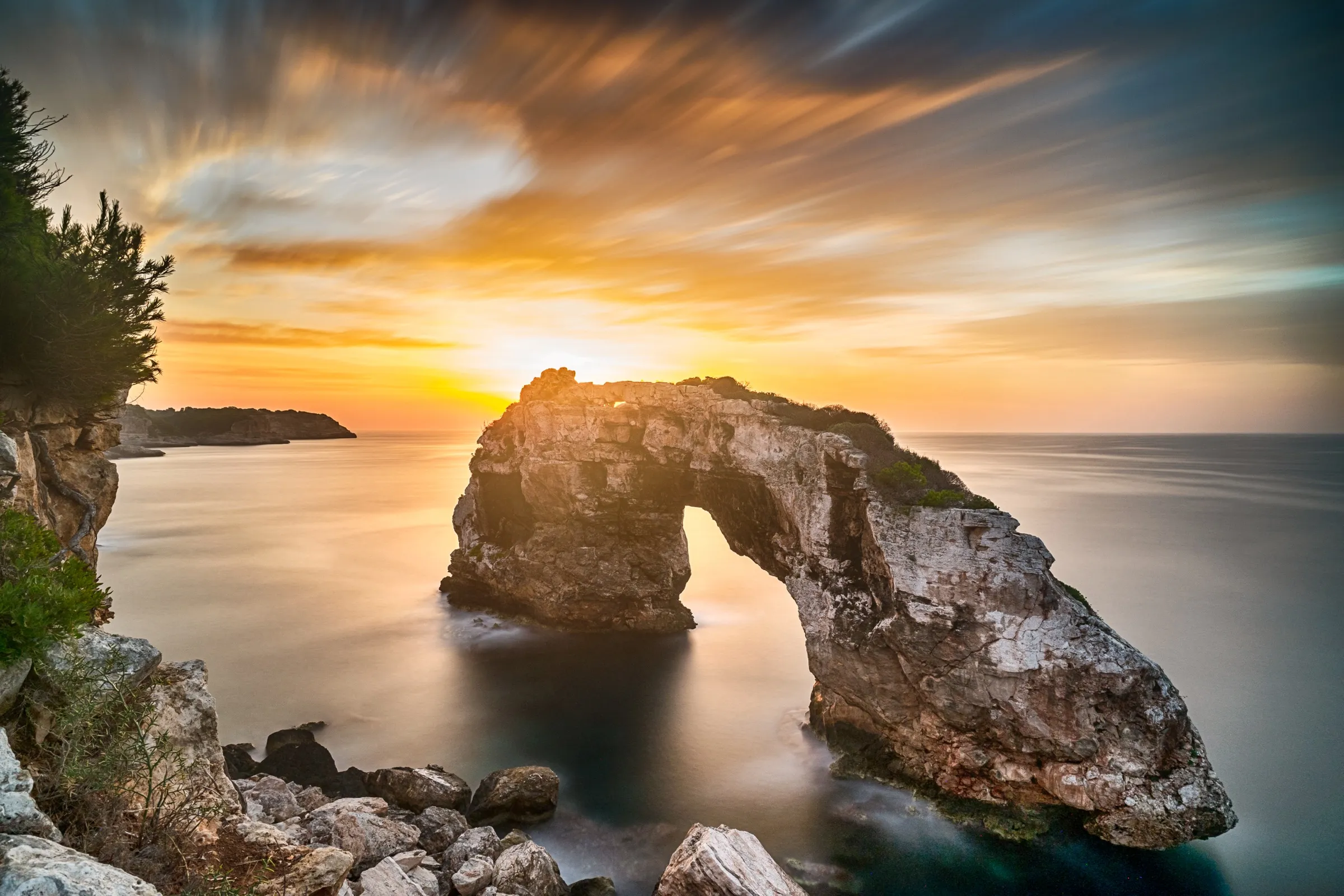 El arco de roca des Pontàs sobre el mar al amanecer, cerca de Cala Santanyí