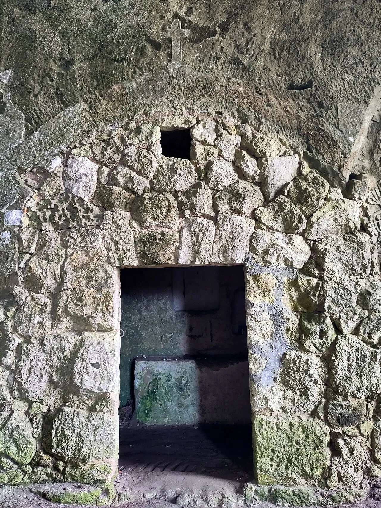 Portal de piedra de la capilla excavada dentro de la Cova de la Mare de Déu